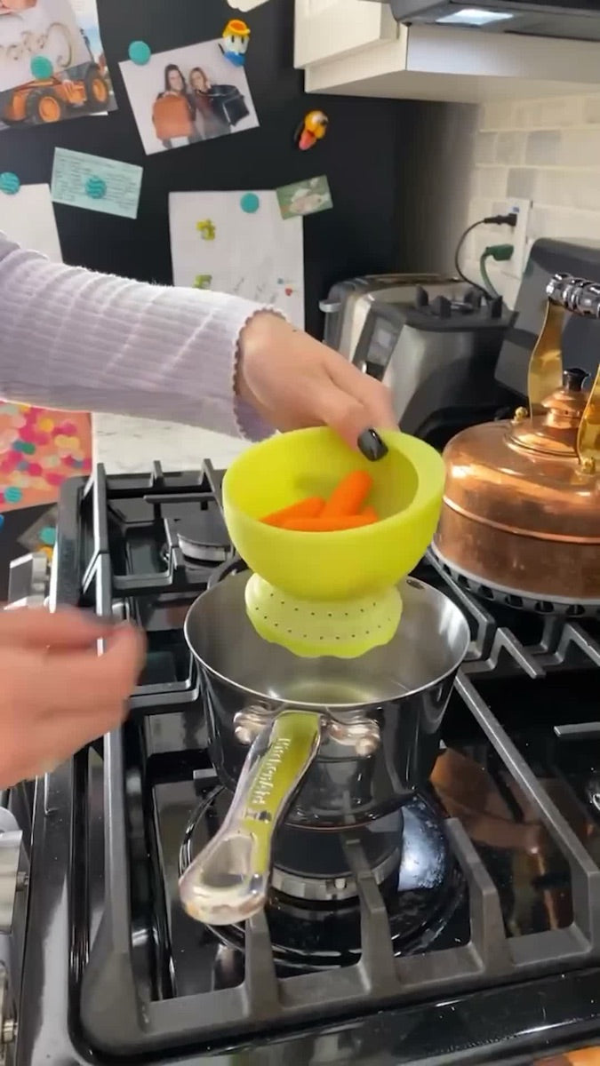 Parent steaming carrots on the stove with the Olababy SteamBowl
