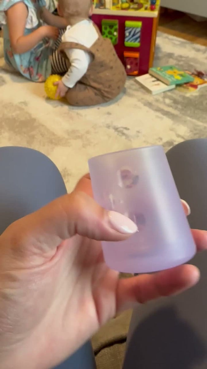 Baby holding the Olababy silicone training cup at home