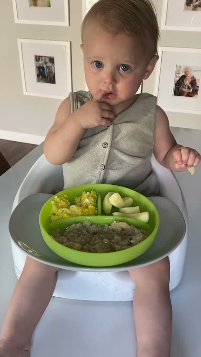 Baby self-feeding from the Olababy divided suction plate