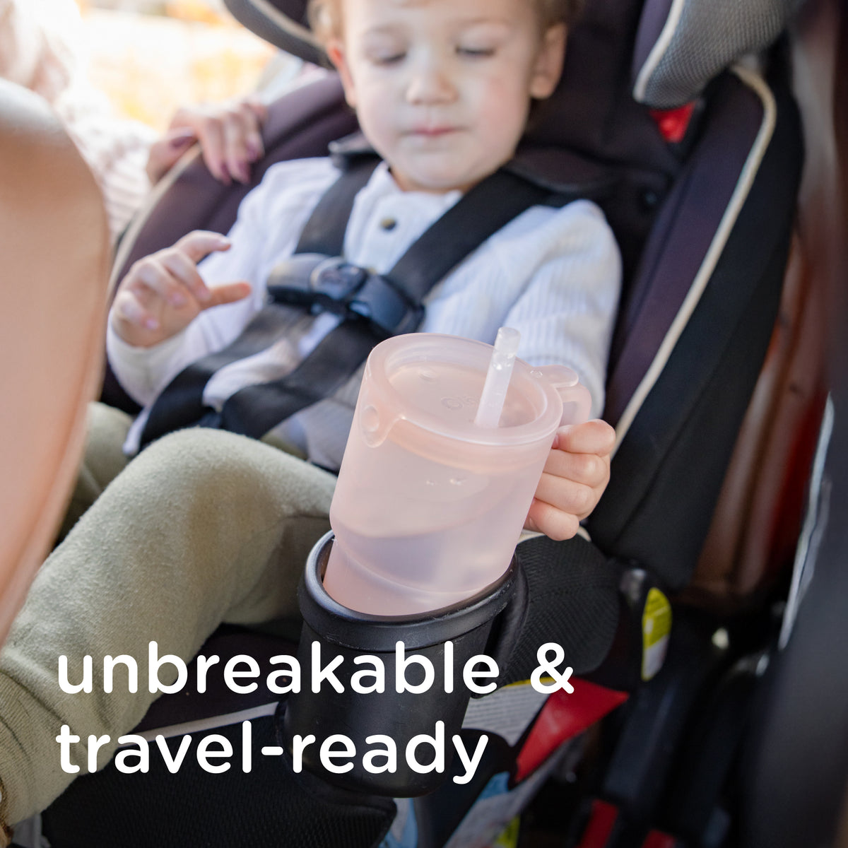 Spill resistant toddler transition cup with straw being used by a child in a car seat for water milk or morning smoothies