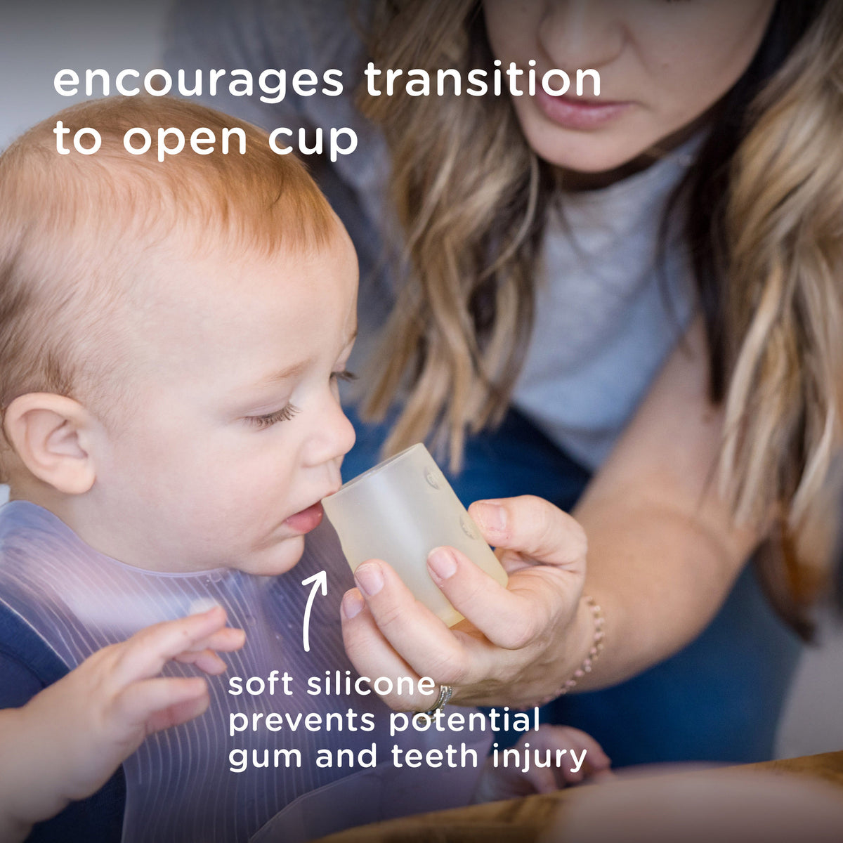 Mother helping her infant transition to an open cup using a soft silicone baby training cup to prevent gum injury