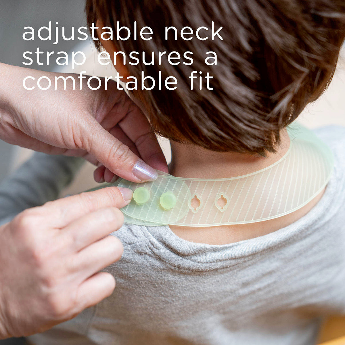 Close up of the adjustable soft neck strap buttons on a flexible silicone toddler bib for a comfortable fit